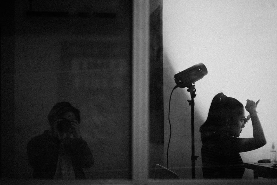 Silhouette of a photographer and model in a studio setting, emphasizing artistic light.